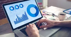 mans-hands-typing-on-laptop-with-graphs-and-data