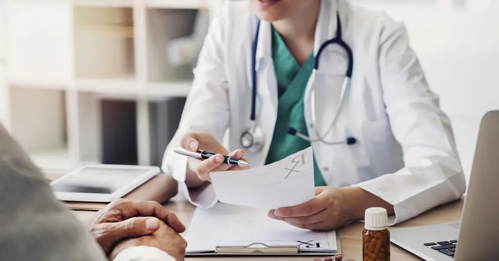 young-doctor-talking-with-patient-writing-prescription-script