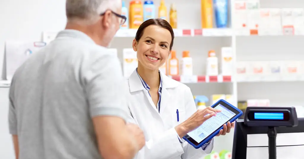 pharmacist-and-customer-with-tablet-in-pharmacy-looking-at-therapeutic-care